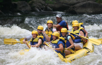 8 people with helmets on in a bright yellow raft whitewater rafting near Happy Acres RV Park in Pueblo CO